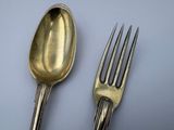 two spoons and a fork on a table