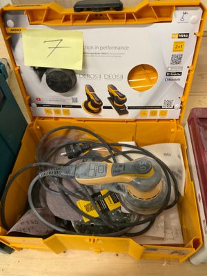 une boîte à outils jaune contenant des outils, posée sur une table