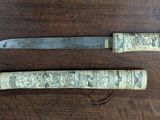 two knives that are sitting on a wooden table