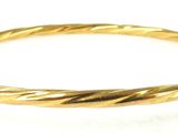 a close up of a gold bracelet on a white surface