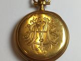 an image of a gold pocket watch sitting on top of a white table