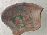 a small bowl with orange dots on it on a white surface