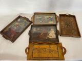 quatre plateaux en bois sur lesquels figurent des photos de personnes, posés sur une table