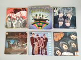 il y a beaucoup de pochettes d'albums des Beatles sur la table