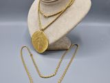 un collier en or et une pièce d'or sur un mannequin
