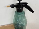 a green bottle with a spray gun on top of a box of fruit