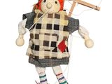 a doll that is holding a wooden cross on it ' s head