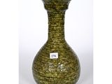 a green vase that is sitting on a white surface
