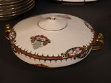 many plates and bowls on the table and one has a lid