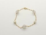 a close up of a bracelet with pearls on a white background