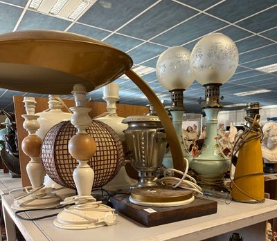 de nombreuses lampes différentes posées sur une table dans une pièce