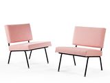 pair of pink lounge chairs with black legs and a pink upholstered seat