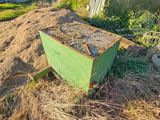 une boîte verte posée au milieu d'un tas de terre