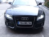 a black audi car parked on the side of the road