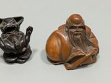 deux figurines représentant un homme et un chat posées sur une table