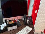 a desk with a computer, keyboard, mouse, and other items on it