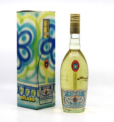 des bouteilles d'alcool posées à côté d'une boîte sur une surface blanche