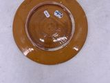 a brown plate on the floor with a sticker on it