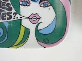 a plate with a picture of a woman blowing a kiss on it