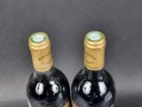 two bottles of wine sitting next to each other on a table