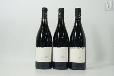 trois bouteilles de vin sont posées sur une table