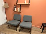 two chairs in the corner of a room with orange walls