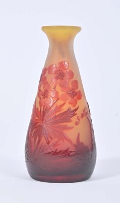 a glass vase with flowers on it on a white surface