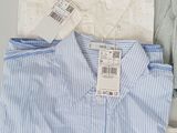 three men ' s shirts on a table with a price tag