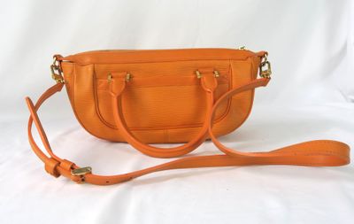 un sac à main orange sur fond blanc, entouré d'une bandoulière
