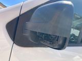 a side view mirror of a white truck with a black emblem on it