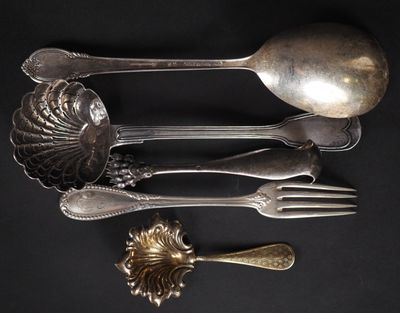 beaucoup de cuillères et de fourchettes en argent posées sur une table noire