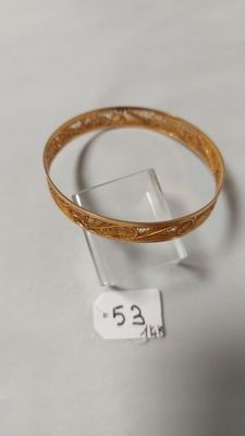 un gros plan d'un bracelet exposé sur une surface blanche