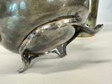a silver vase that is sitting on a table