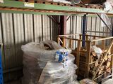 a man standing next to a pile of wood in a warehouse
