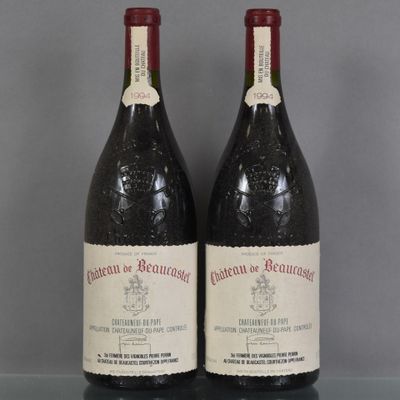 Deux bouteilles de vin sont posées sur une table en verre, sur un fond gris.