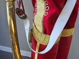 a statue of a man dressed in a red uniform holding a sword