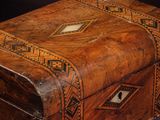 an old wooden box sitting on a purple surface