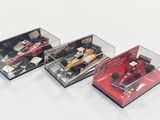 trois modèles différents de voitures de course dans une vitrine
