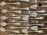 a lot of silver spoons and forks on a wooden table