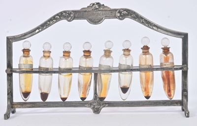 five glass bottles with liquid in them on a metal rack