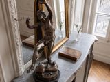 une statue représentant une femme assise sur une table dans une pièce