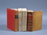 trois livres sont empilés sur une table