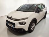 Une Citroën blanche est garée dans une pièce blanche