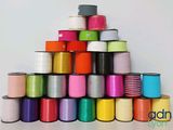 many spools of different colors of thread on a table