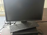 a computer monitor and keyboard on a desk with a mouse and keyboard