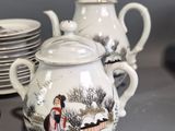 many plates and cups and a teapot on the table