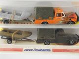 three toy vehicles in a clear box on a white surface