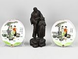 two decorative plates with a statue of a man and a woman on them