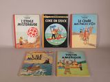 plusieurs livres sont alignés sur une table à fond blanc