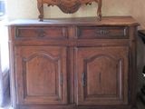 a wooden cabinet with wine glasses on top of it
